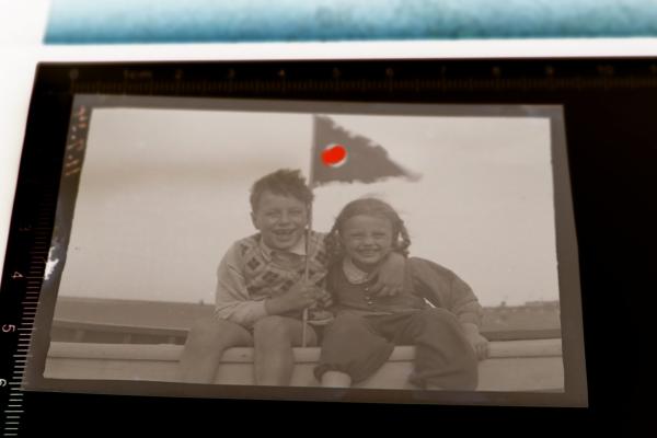 altes Negativ - Mädchen und Junge lachen in die Kamera und halten Hakenkreuz-Wimpel